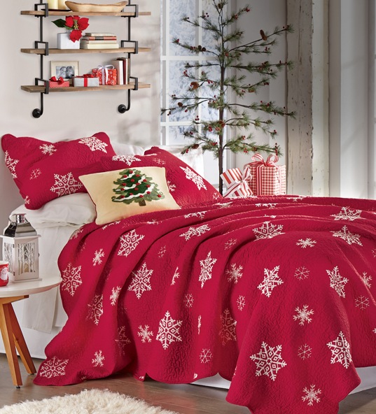 Banner: Red Snowflake Quilt on a bed with Christmas tree accent pillow, shelf above and Christmas tree behind.